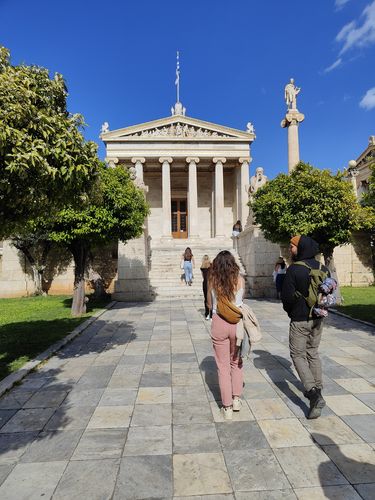 Zwei Menschen vor dem Eingang eines historischen Gebäudes in Athen bei Tag