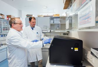 Direktor Prof. Dr. Hendrik Bläker und Prof. Dr. Maximilian von Laffert vom Institut für Pathologie überprüfen die Arbeiten vom Tumor-Sequenziergerät.
