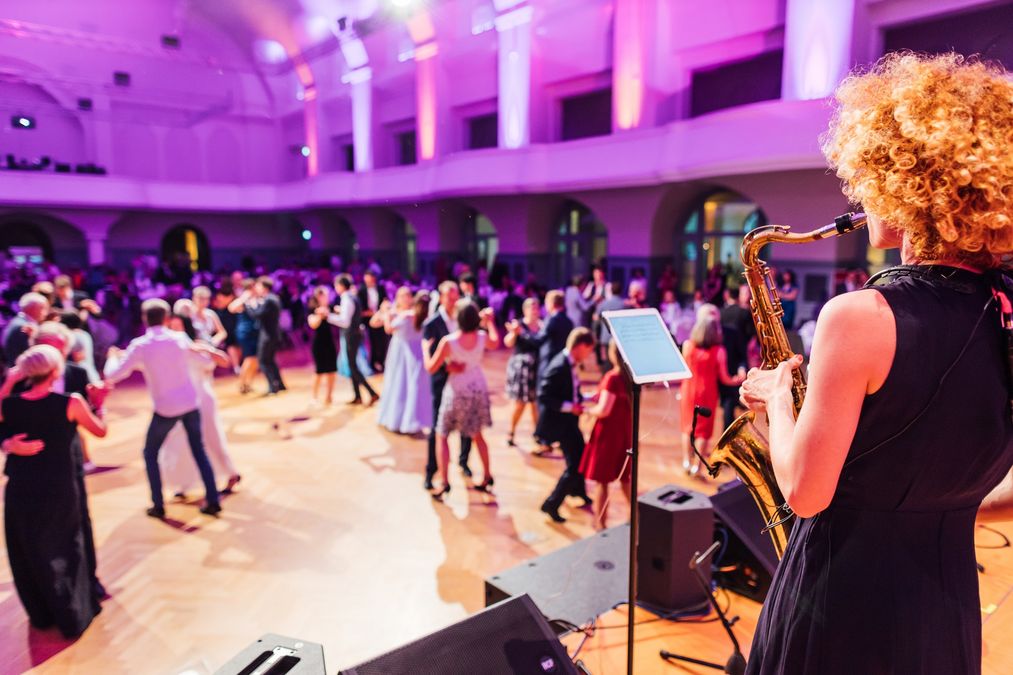 zur Vergrößerungsansicht des Bildes: Saxofonspierlein für einem tanzenden Publikum in einem Ballsaal