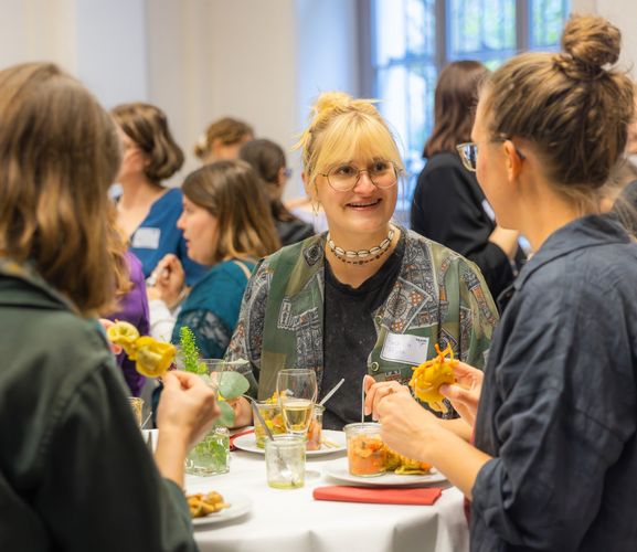 Drei Personen essen gemeinsam und unterhalten sich.