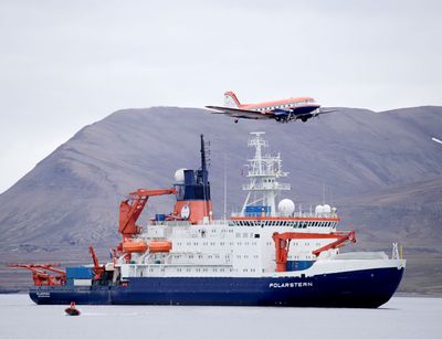 Das Forschungsfluzeug Polar 5 überfliegt das Forschungsschiff Polarstern bei einem Zwischenstopp auf Spitzbergen. Foto: Thomas Krumpen, Alfred-Wegener-Institut