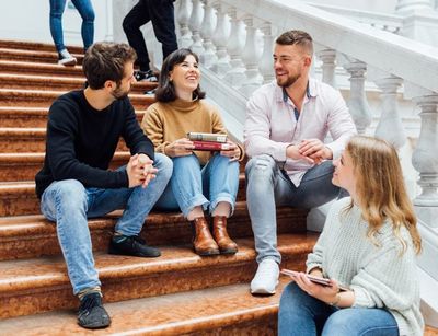 Eine Gruppe Studierende im Gespräch auf der Treppe sitzend in der Bibliotheca Albertina der UNiversität Leipzig