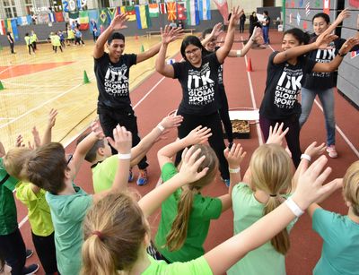 Das Bild zeigt ITK-Trainer:innen bei einem Sportfest mit Kindern in einer Sporthalle. 