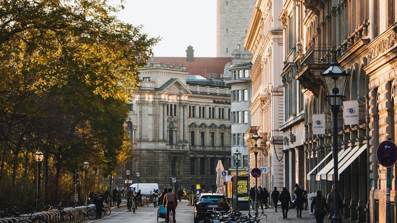 Das Foto zeigt einen Blick in eine Straße zwischen großen und alten Gebäuden. 