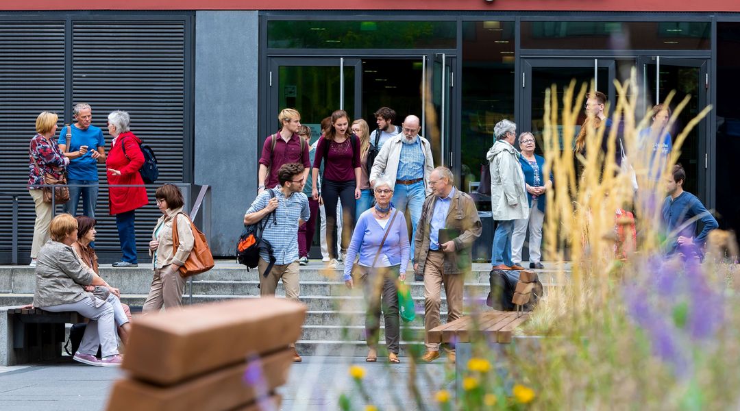 Studierende der Seniorenakademie kommen aus dem Hörsaalgebäude